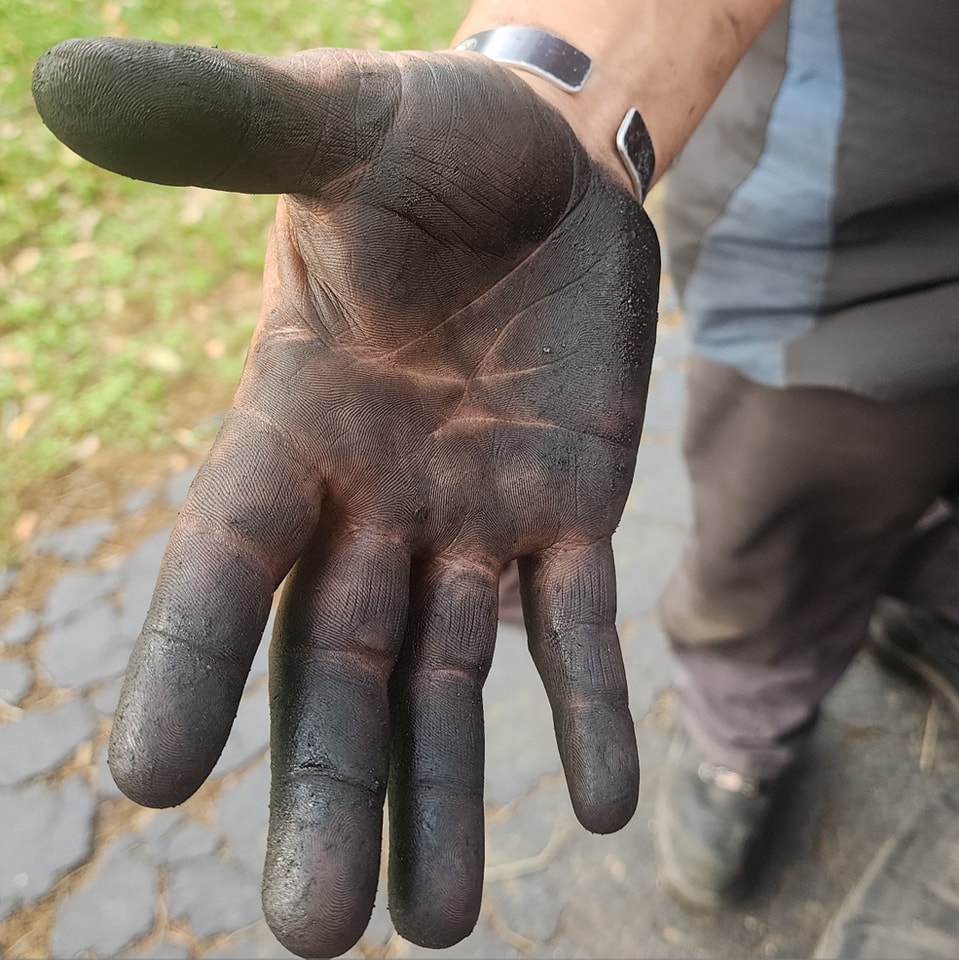 A mechanic's grease-covered hand after a day of work